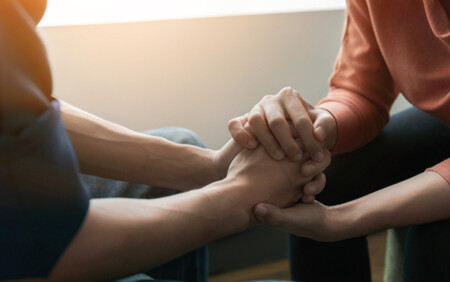 two people holding hands in a supportive way