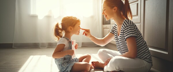 Mother and daughter sitting on floor playing