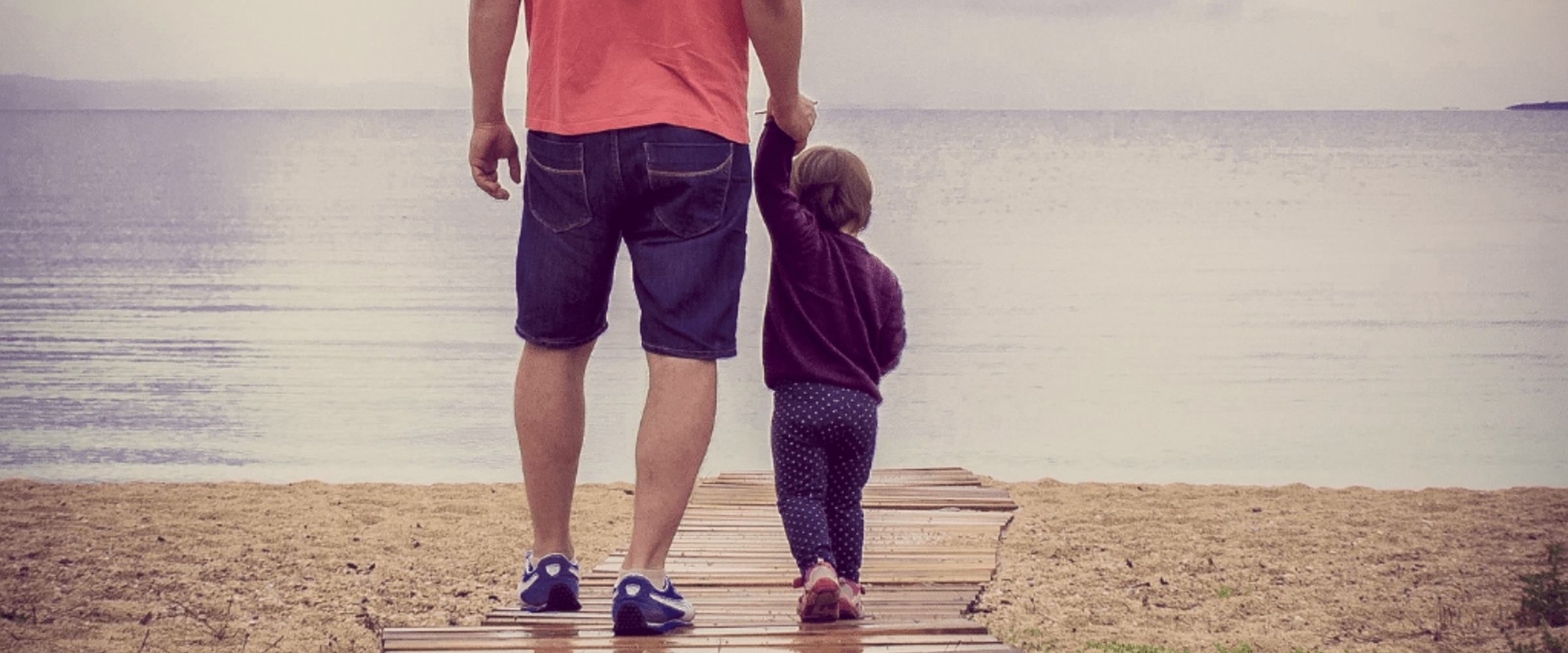 man and child walking along pier